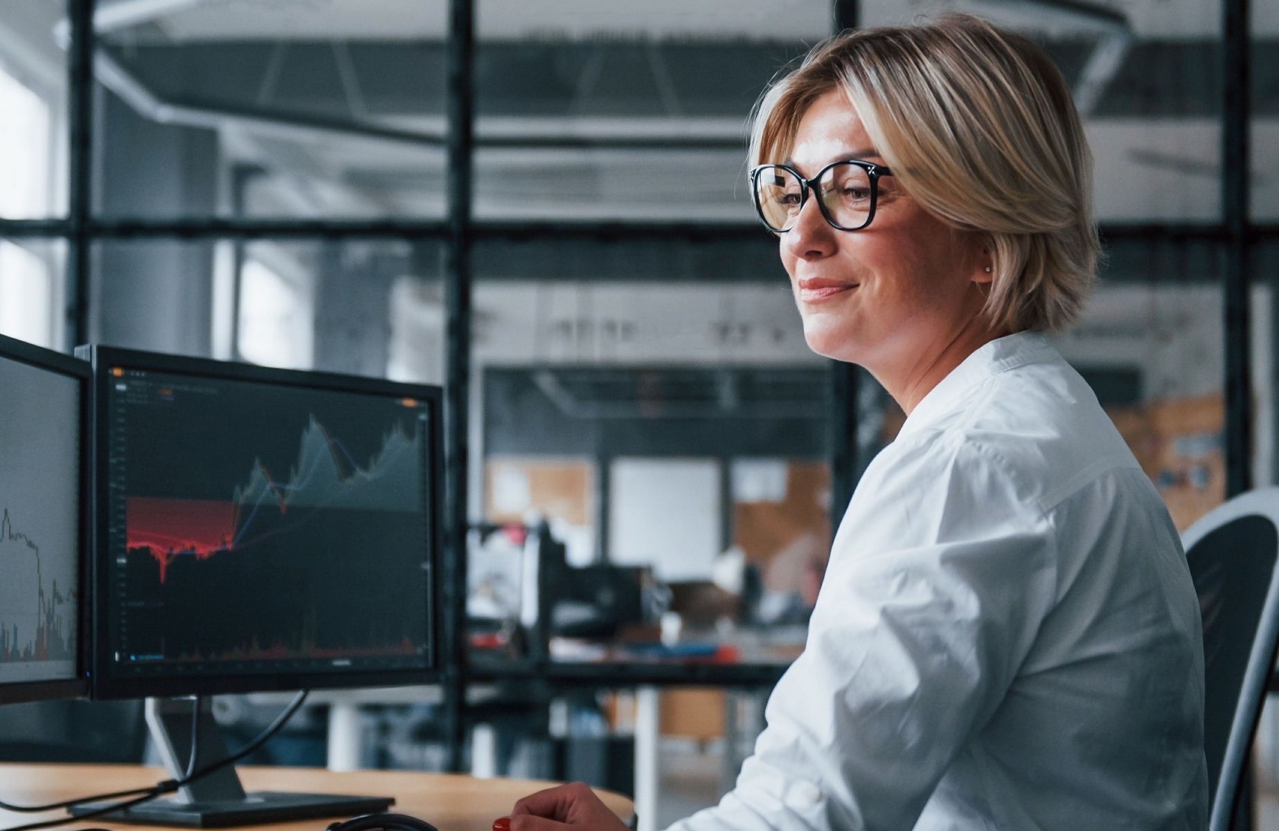 Woman at desk in front of computers